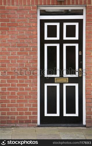 Front Door, Traditional English Victorian in England, United Kingdom. Black and White Door With a Brick Wall