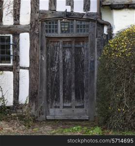 Front entrance doorway to an old Tudor cottage, Warwickshire, England.