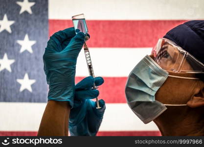 Front Line Worker Holding Syringe and Vial Filled with Coronavirus Vaccine or Medicine Silhouetted Against American Flag.