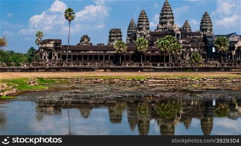Front of Angkor Wat with reflection in water. Front of Angkor Wat with reflection in water and a blue sky above