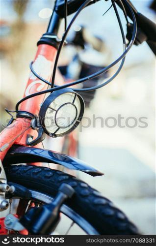 Front picture of a city bike, head lamp and blurry background