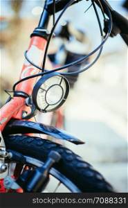 Front picture of a city bike, head lamp and blurry background