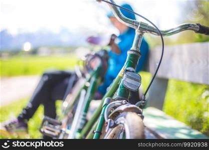 Front picture of a vintage retro bike, head reflectors. Girl sitting in blurry background.