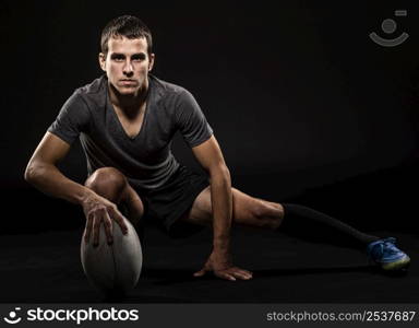front view athletic handsome rugby player holding ball with copy space