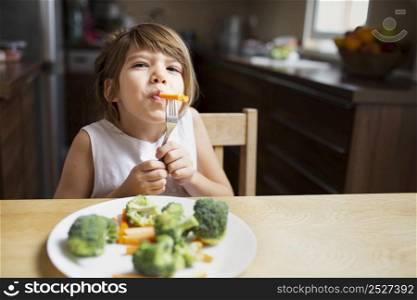 front view baby girl having vegetables