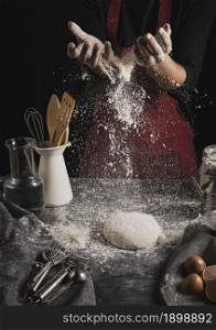 front view baker hands spreading flour. Resolution and high quality beautiful photo. front view baker hands spreading flour. High quality beautiful photo concept