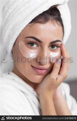 front view beautiful smiley woman using eye patches