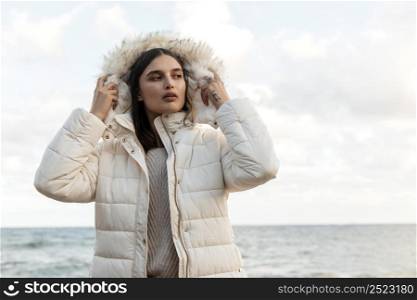 front view beautiful woman beach with winter jacket