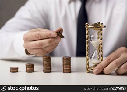 front view businessman with coins hourglass