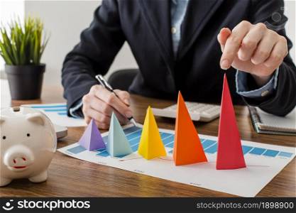front view businessman with colorful cones representing growth. Resolution and high quality beautiful photo. front view businessman with colorful cones representing growth. High quality beautiful photo concept