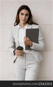 front view businesswoman holding tablet coffee cup