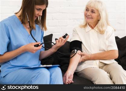 front view checking old woman s blood pressure