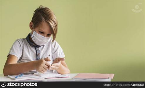 front view child with medical mask disinfecting hands class with copy space