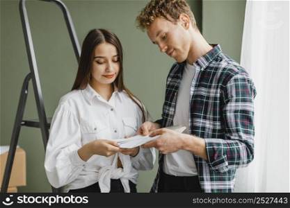 front view couple making plans redecorate house using paint palette