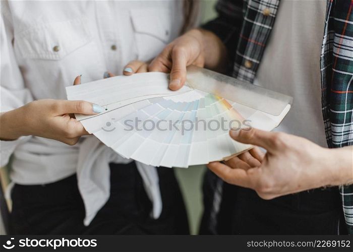 front view couple making plans redecorate house while holding paint palette