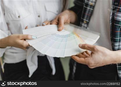 front view couple making plans redecorate house while holding paint palette