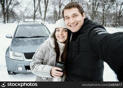 front view cute couple taking selfie while road trip