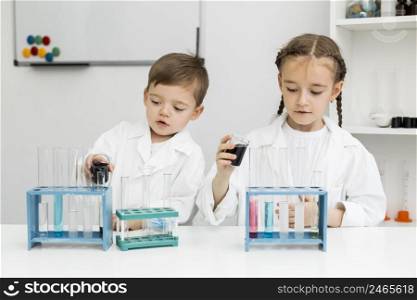 front view cute young kids scientists with test tubes laboratory