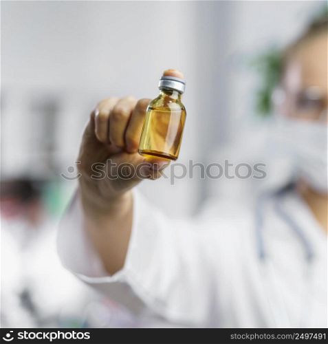 front view defocused female researcher with vaccine bottle