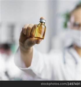 front view defocused female researcher with vaccine bottle