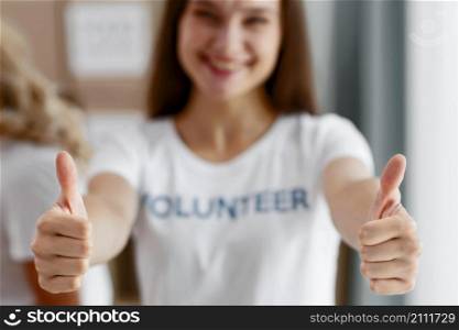 front view defocused female volunteer giving thumbs up