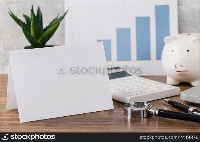 front view desk with blank paper piggy bank