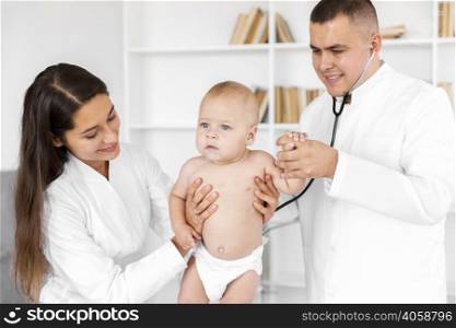 front view doctors holding adorable baby