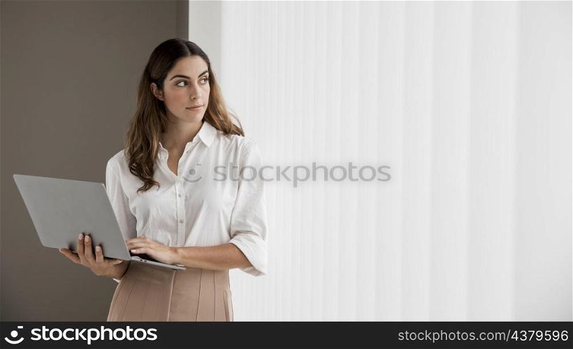 front view elegant businesswoman holding laptop with copy space