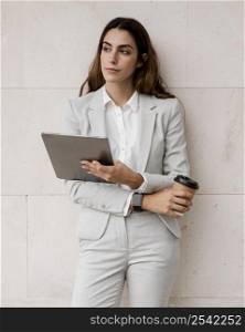 front view elegant businesswoman holding tablet coffee cup