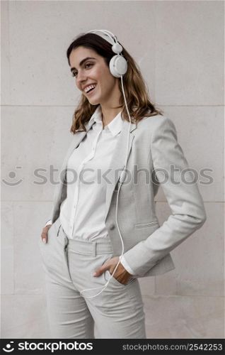 front view elegant businesswoman listening music headphones