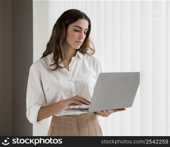 front view elegant businesswoman using laptop