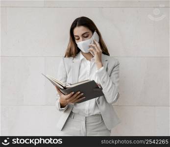 front view elegant businesswoman with mask talking phone