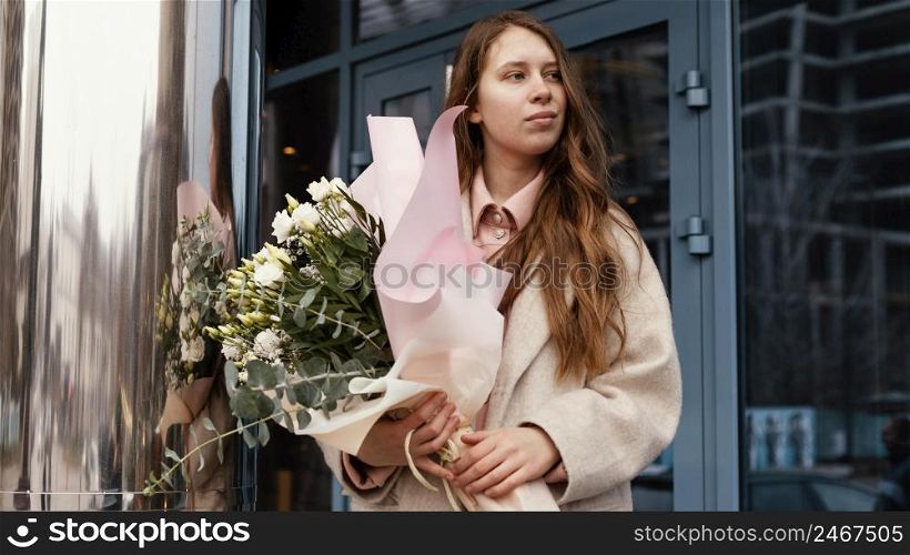 front view elegant woman holding bouquet flowers outdoors