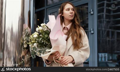 front view elegant woman holding bouquet flowers outdoors