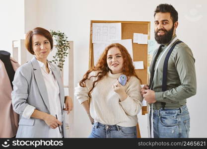 front view fashion designers posing their business atelier