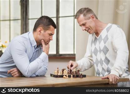 front view father son playing chess