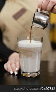 front view female barista pouring coffee milk glass