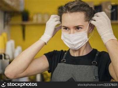 front view female barista putting medical mask