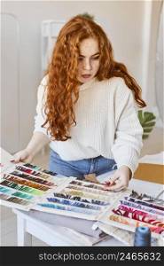 front view female fashion designer working atelier with color palette