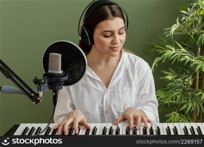 front view female musician playing piano keyboard