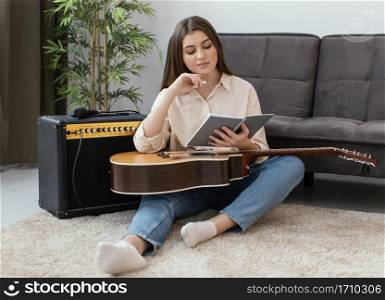 front view female musician with acoustic guitar writing songs