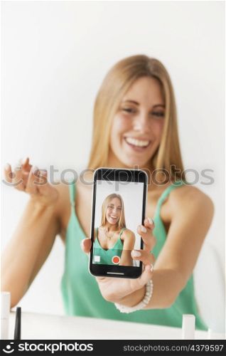 front view female recording herself with mobile