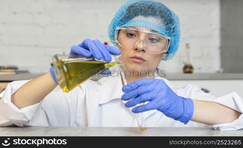 front view female researcher with safety glasses hair net doing science experiments