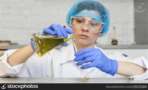 front view female researcher with safety glasses hair net doing science experiments