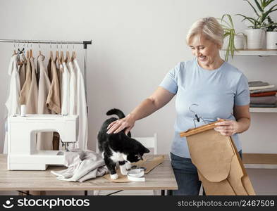 front view female seamstress studio with cat