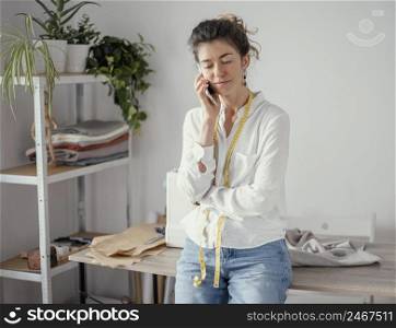 front view female tailor talking phone