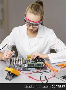 front view female technician with soldering iron electronics board