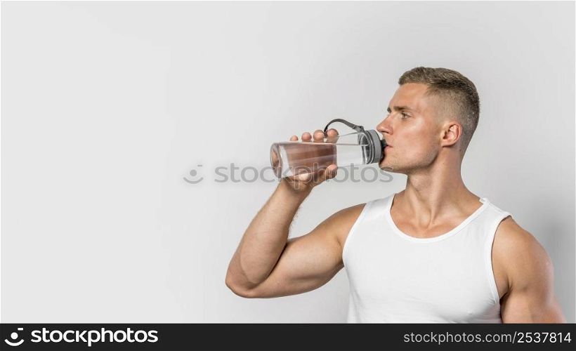 front view fit man drinking from water bottle