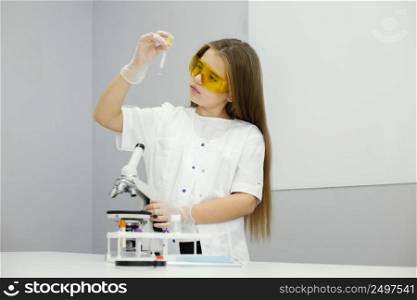 front view girl scientist with microscope test tube