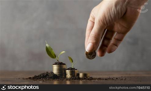 front view hand adding coins stack covered dirt plants. High resolution photo. front view hand adding coins stack covered dirt plants. High quality photo